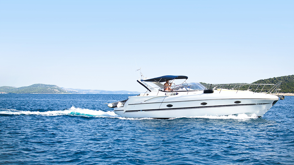 Kjøp og salg av bruktbåt. En båt kjører i lav fart i skjærgården.